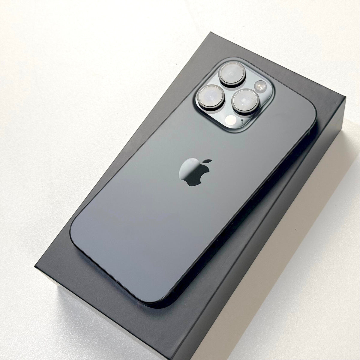 Black Titanium iPhone 16 Pro back with triple camera, in box