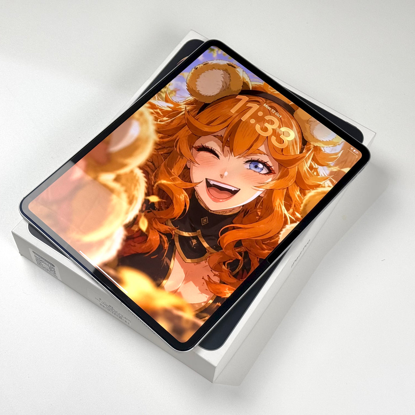 Pre-owned iPad Pro 13-inch M5 Silver, screen on, resting on its box - Mac Shack
