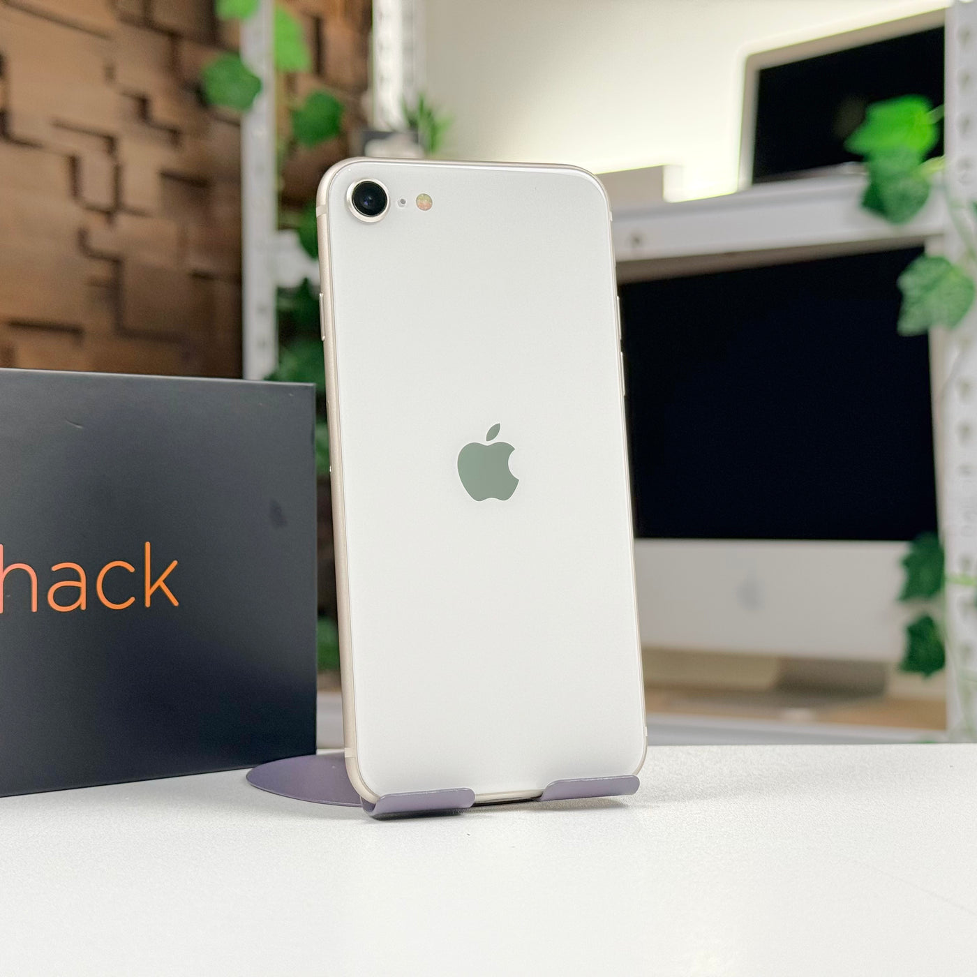 Pre-owned iPhone SE 3rd Gen 64GB Starlight standing beside Mac Shack box, rear view - Mac Shack