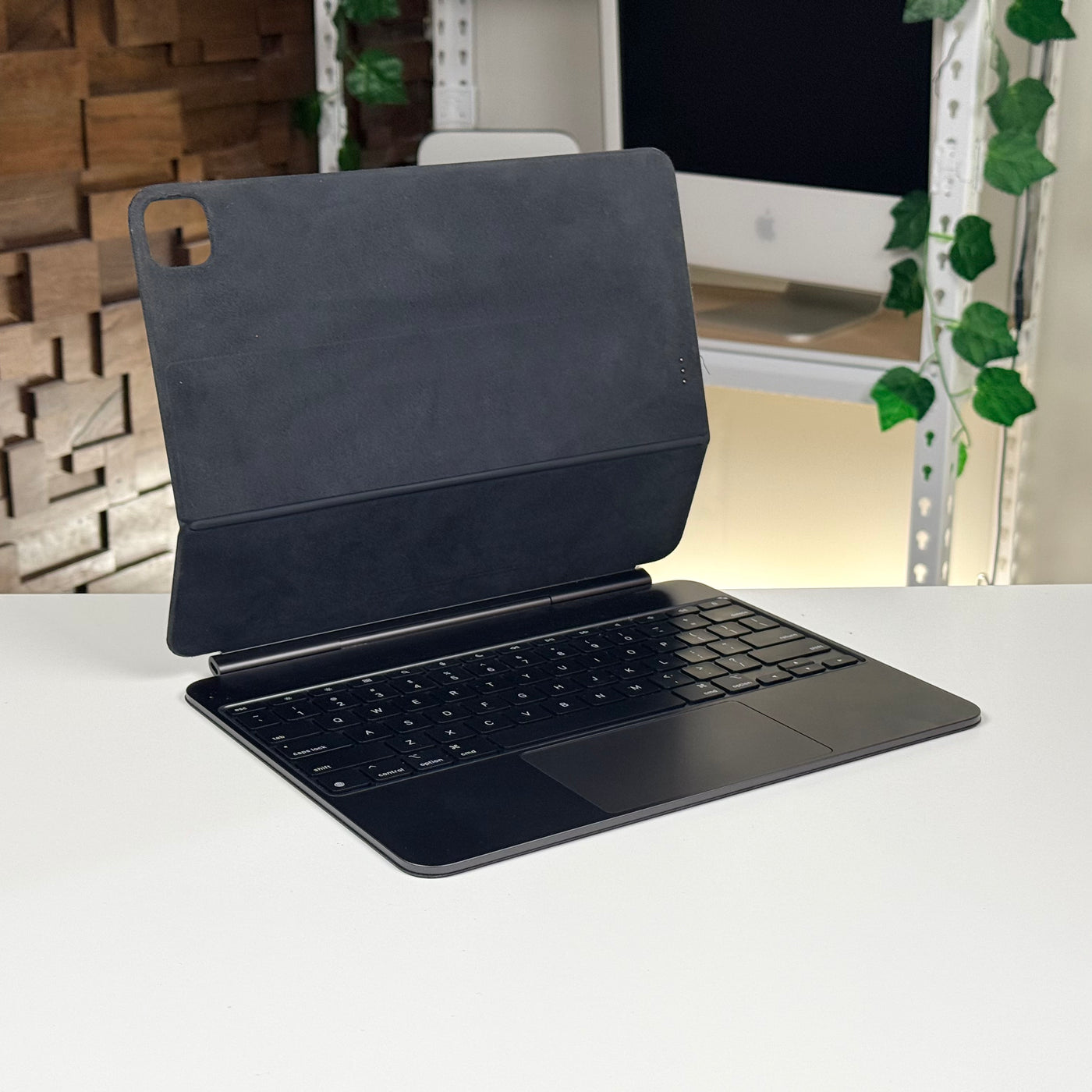 Pre-owned black Apple Magic Keyboard for iPad Pro 13-inch, open on a desk – actual unit
