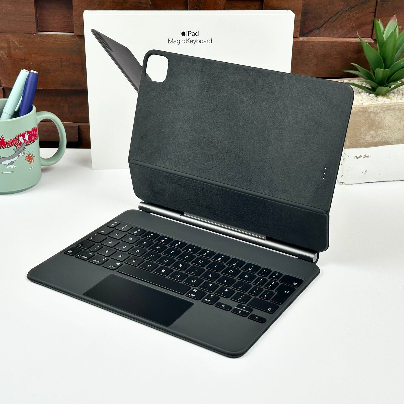 Pre-owned black Apple Magic Keyboard for iPad Pro 11-inch and iPad Air, open in front of its original box