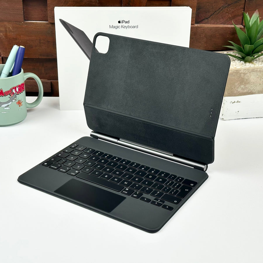 Pre-owned black Apple Magic Keyboard for iPad Pro 11-inch and iPad Air, open in front of its original box