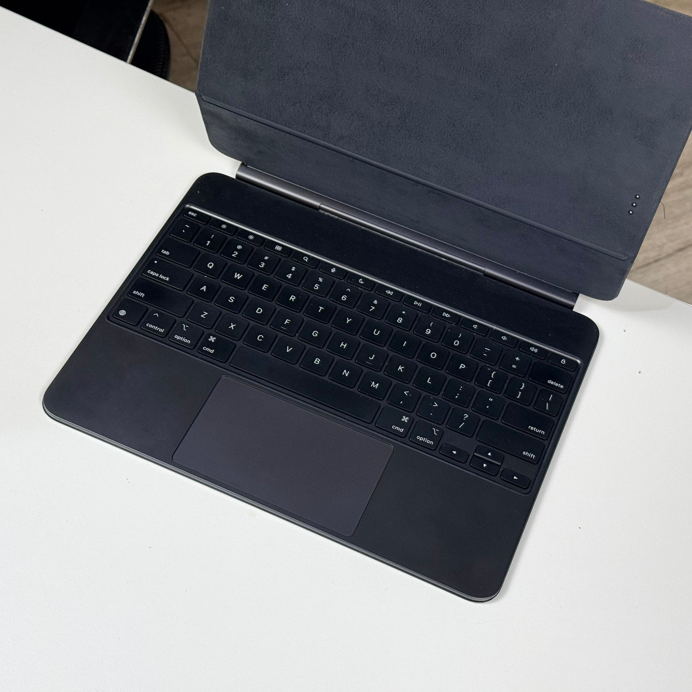 Close-up of the backlit keys and trackpad on the pre-owned black Apple Magic Keyboard for iPad Pro 13-inch – actual unit