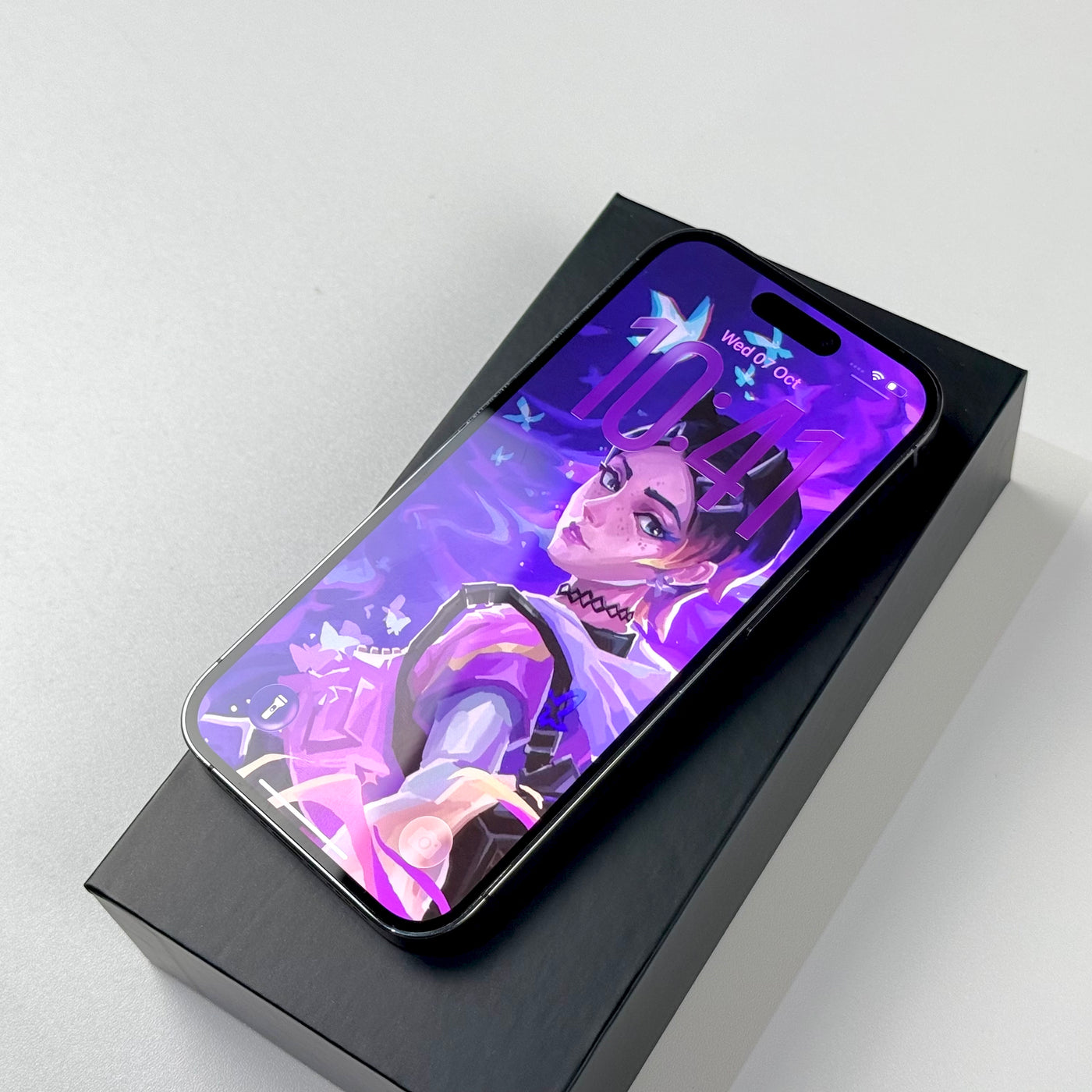 Pre-owned iPhone 14 Pro 256GB Deep Purple, screen on, resting on its box - Mac Shack