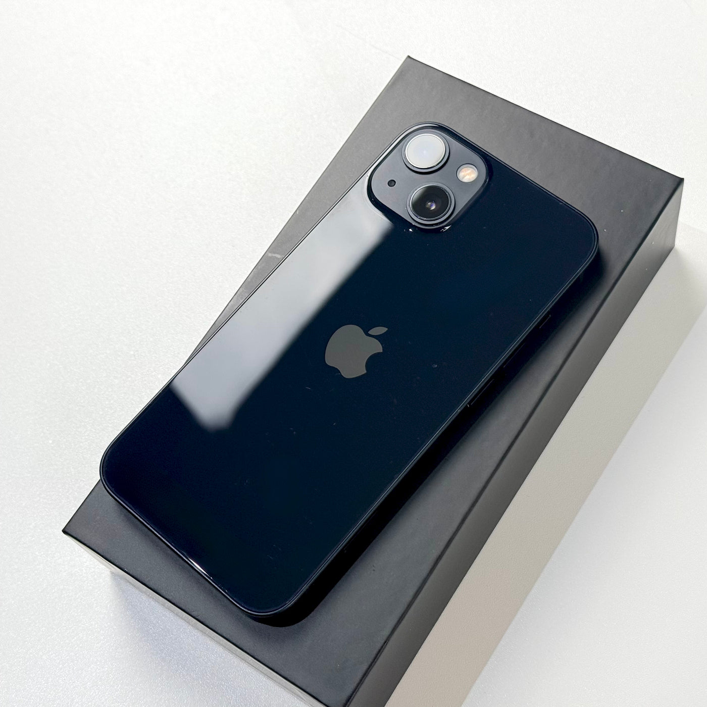 Back of pre-owned iPhone 13 Midnight in box showing dual camera - Mac Shack