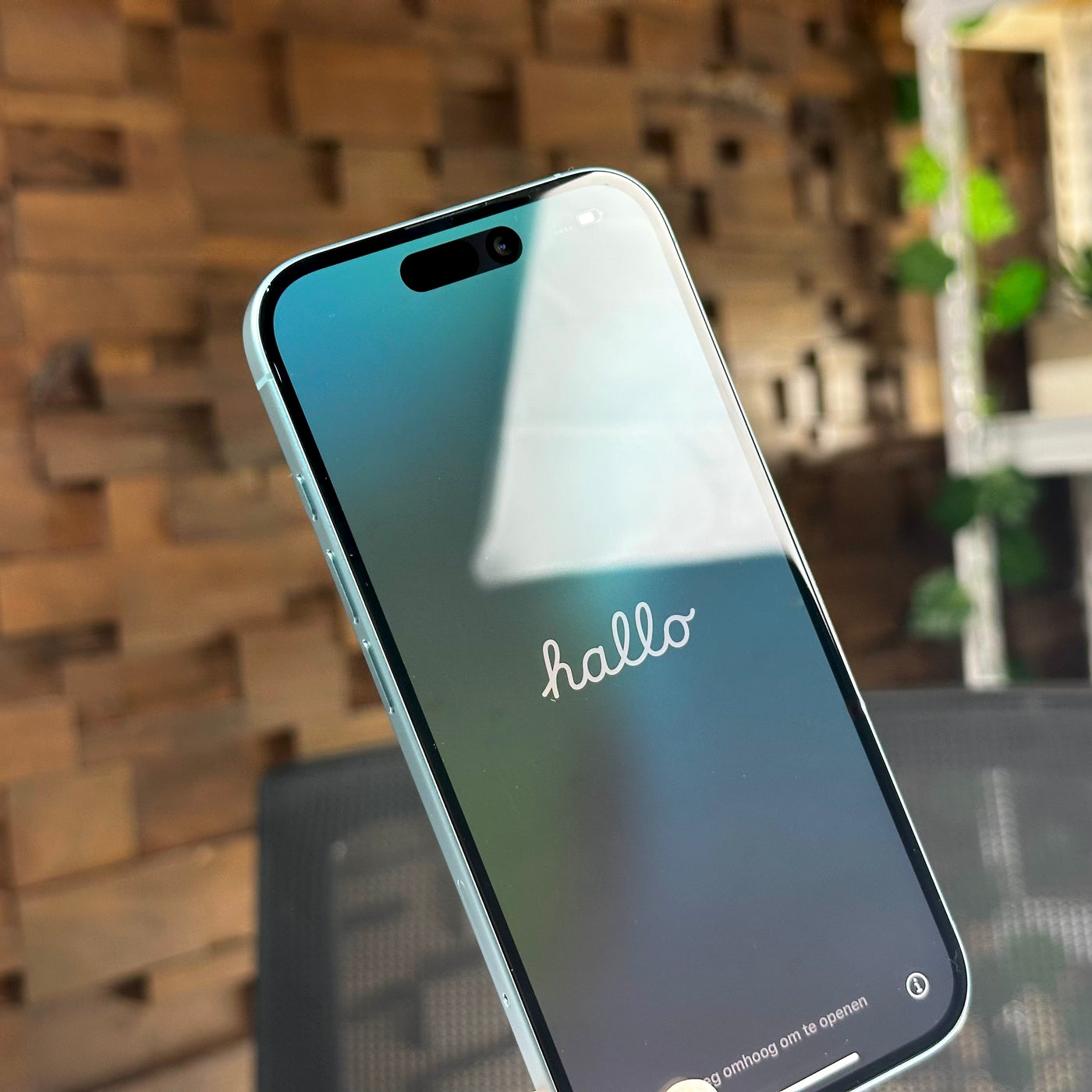 Angled front view of the pre-owned iPhone 16 in Teal with the screen on - Mac Shack