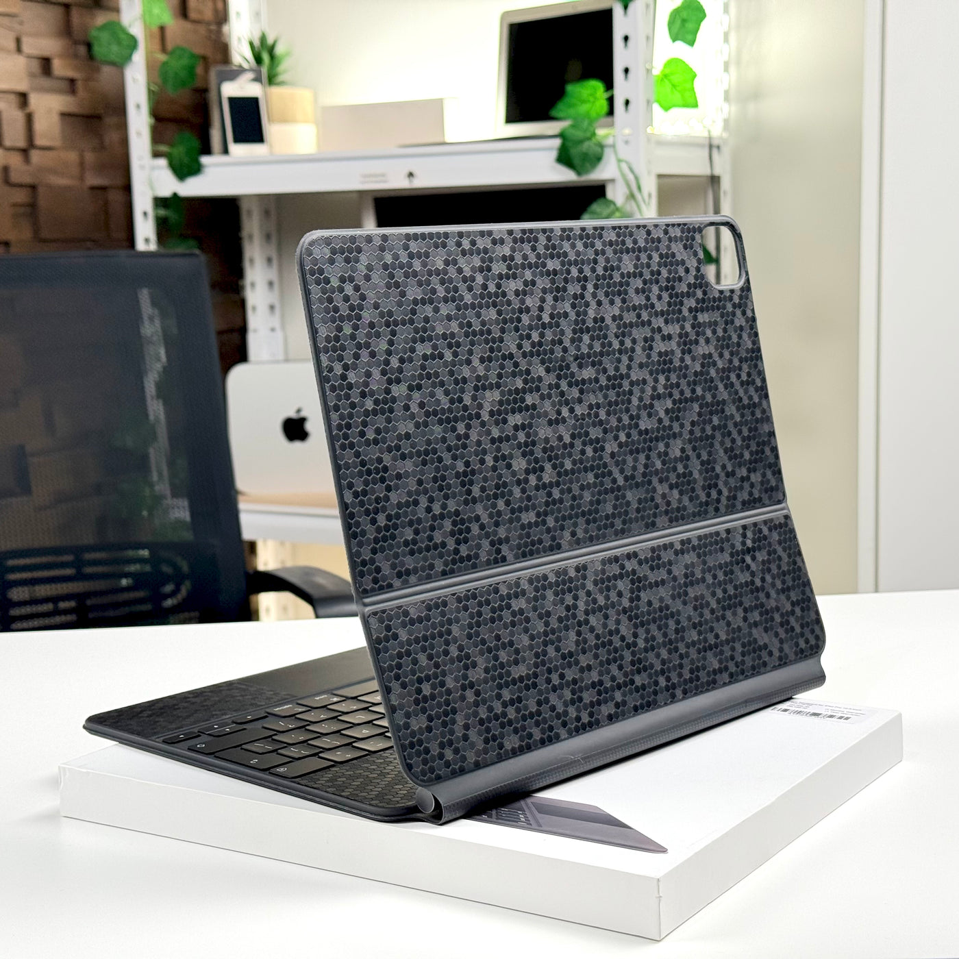 Back of a pre-owned Magic Keyboard for iPad Pro 12.9-inch with textured grey skin, standing open