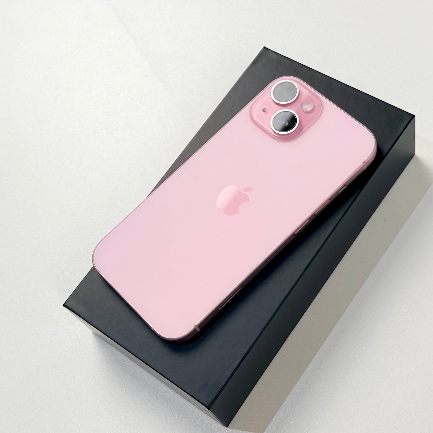 Pink iPhone 15 back with dual camera, in box