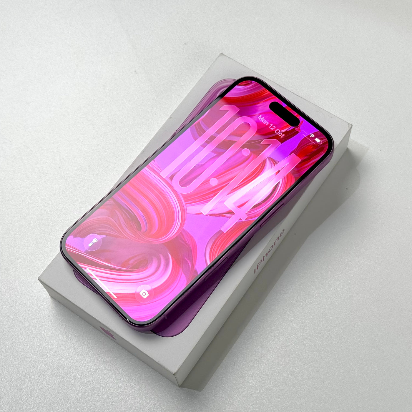 Pre-owned iPhone 16 128GB Pink, screen on, resting on its box - Mac Shack